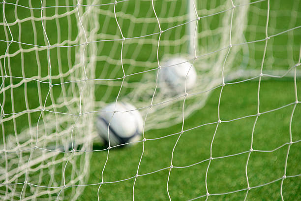 Football net with out-focus balls in background stock photo