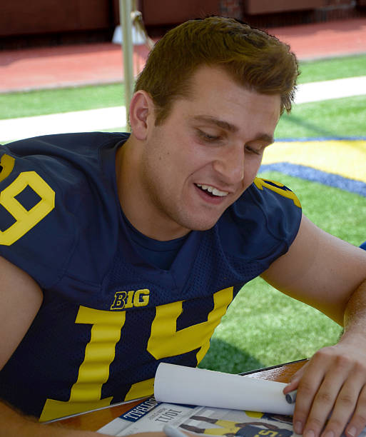 UM football player 19 Jared Wangler Ann Arbor, MI - August 10, 2014: University of Michigan football player Jared Wangler pauses between autographs at Michigan Football Youth Day on August 10, 2014 in Ann Arbor, MI. michigan football stock pictures, royalty-free photos & images
