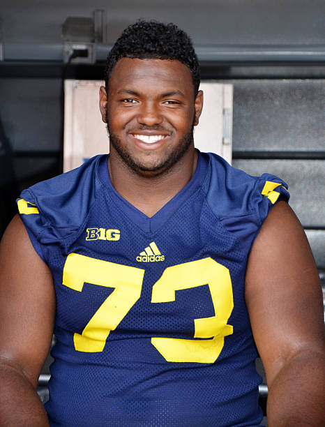 UM football player 73 Maurie Hurst Jr. Ann Arbor, MI - August 10, 2014: University of Michigan football player Maurie Hurst Jr. pauses between autographs at Michigan Football Youth Day on August 10, 2014 in Ann Arbor, MI. michigan football stock pictures, royalty-free photos & images