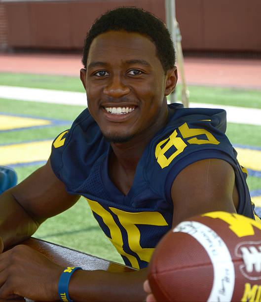 UM football player 85 Maurice Ways Ann Arbor, MI - August 10, 2014: University of Michigan football player Maurice Ways pauses between autographs at Michigan Football Youth Day on August 10, 2014 in Ann Arbor, MI. michigan football stock pictures, royalty-free photos & images