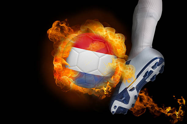 football player kicking flaming netherlands ball - michigan football stok fotoğraflar ve resimler