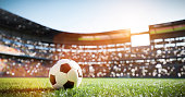 istock Football soccer ball on grass field on stadium 1312143573