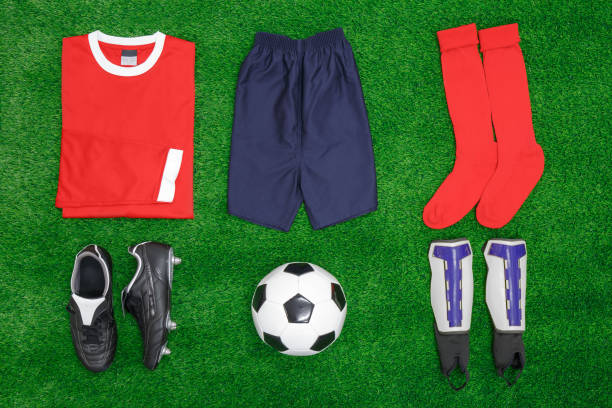 Football Soccer flat lay A flat lay arrangement of football or soccer kit on grass, with shirt, shorts,socks, boots, shin pads and ball. equipación fútbol stock pictures, royalty-free photos & images