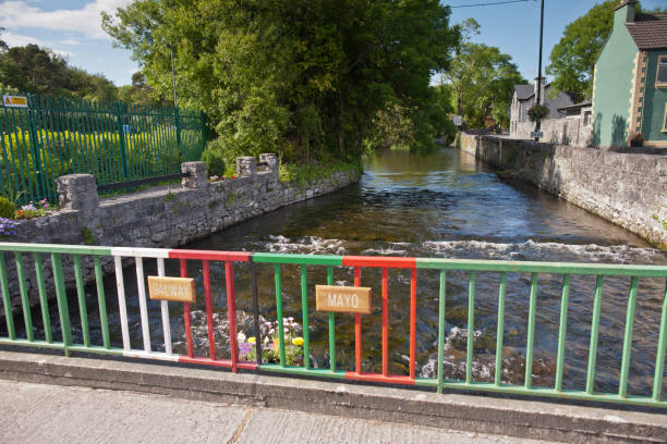 Footbridge over River Cong, Cong Village on the  County Mayo/Galway border, Ireland Colorful railings highlight the county border, the centerline of River Cong.  To the left are the salmon Fishery grounds.  County Galway/Mayo michael stephen wills cong stock pictures, royalty-free photos & images