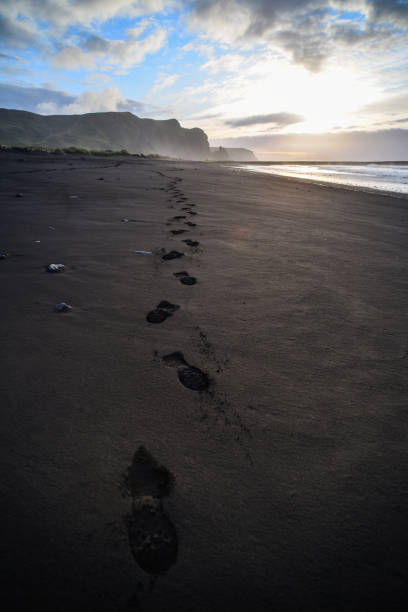 Footsteps in the black sand stock photo