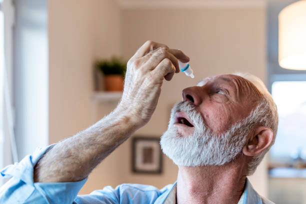 For better vision A man dropping eye drop medicine healing his eye pain- health care eye medicine with people concept. Vision and ophthalmology medicine, health concept, side view of Senior gray hair man applying eye drop. A mature man dropping medicine in his eye with eye-dropper. allergy medicine stock pictures, royalty-free photos & images