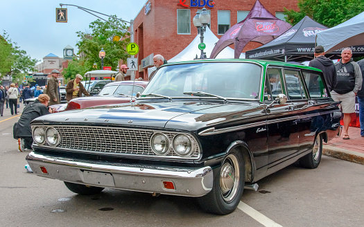Moncton, New Brunswick, Canada - July 8, 2016 : 1963 Ford Fairlane station wagon parked in downtown area during 2016 Atlantic Nationals, Moncton, New Brunswick, Canada. People walk on the sidewalk and among the classic autos in the downtown area.