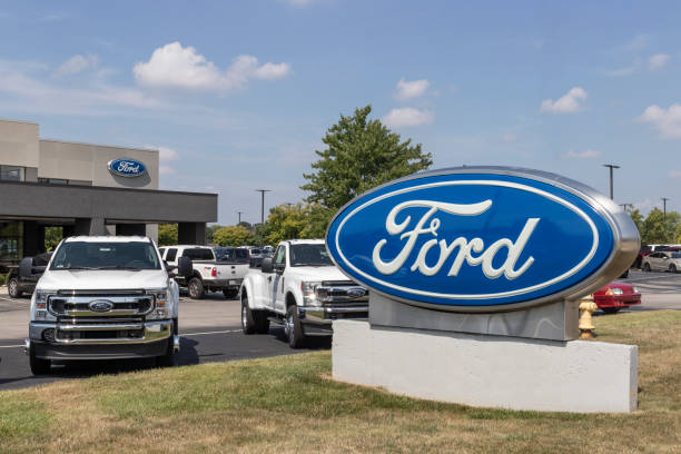 Ford F-Series Truck display at a dealership. Ford sells traditional gasoline, electric and hybrid SUV models. stock photo