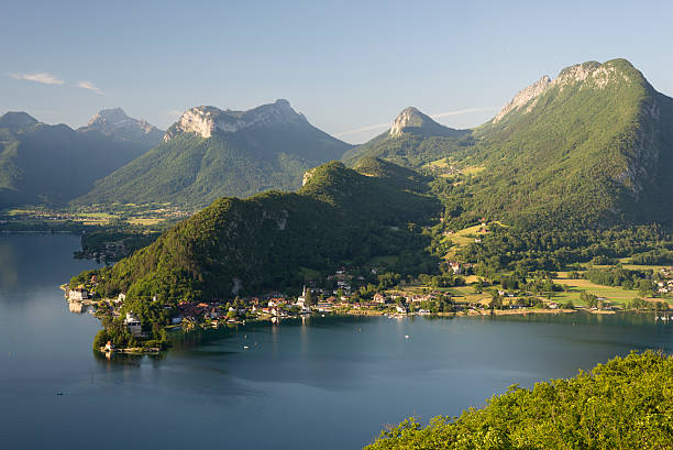 Forests and mountains at the Lake Annecy after sunrise stock photo