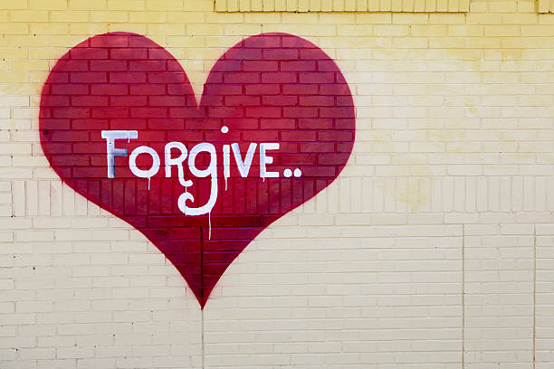 Forgive Raleigh, NC, USA - April, 4, 2011. Graffiti on abandoned warehouse gives a simple message: forgive. Local graffiti artists make their mark around the city\'s urban areas. forgiveness stock pictures, royalty-free photos & images
