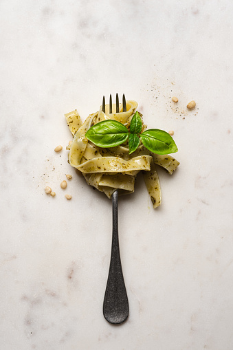 Fork with pasta, pesto and basil