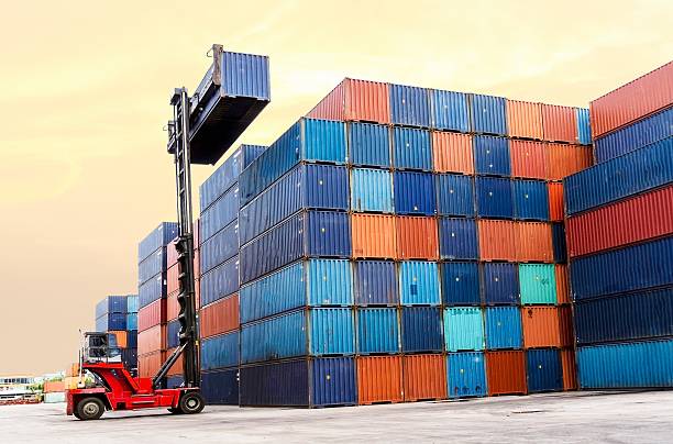 Forklift handling the container box at dockyard stock photo