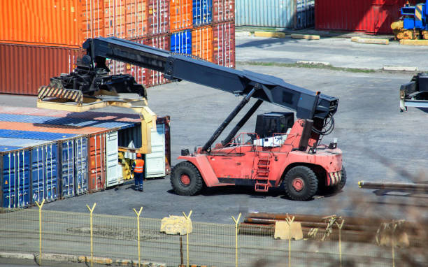 Forklift loads business wood container at container terminals. Logistics import export background and transport industry of forklift handling container box loading at seaport. Export import wood. stock photo