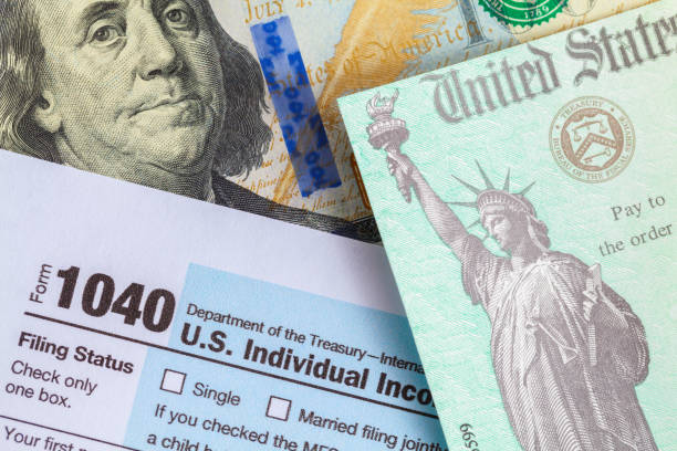 Form 1040 With Tax Check and Money Tax Refund Check On top of Form 1040 and One Hundred Dollar Bill. stimulus check stock pictures, royalty-free photos & images