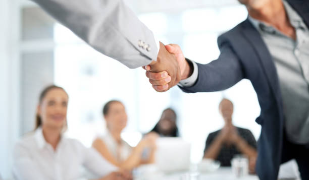 Closeup shot of two unrecognisable businesspeople shaking hands during a meeting in a boardroom