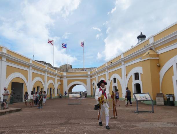 Fort El Morro, Puerto Rico OLD SAN JUAN, PUERTO RICO—MARCH 2017: A man in costume who reenacts the 1797 battles in Puerto Rico once a month walks at the Plaza de Armas at the El Morro Fort, Old San Juan District in Puerto Rico. historical reenactment stock pictures, royalty-free photos & images