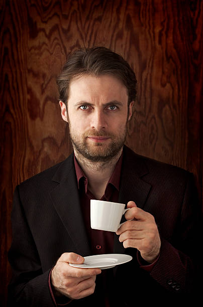 Middle aged caucasian man in a suit drinking coffee. Portrait on a...