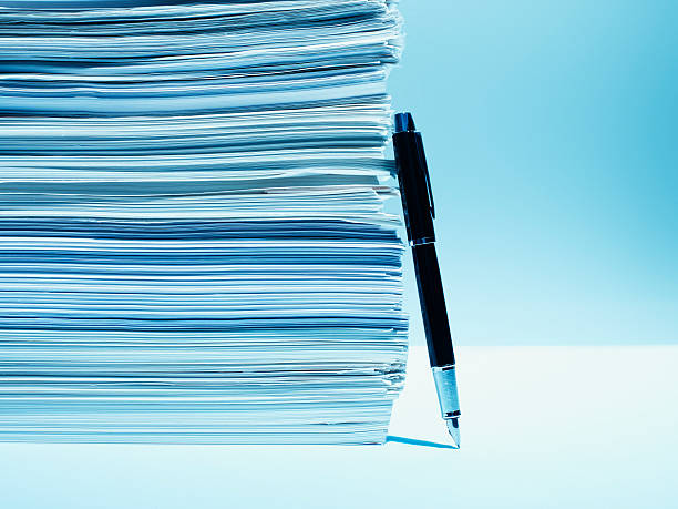 Fountain pen leaning against stack of paper  bureaucracy stock pictures, royalty-free photos & images