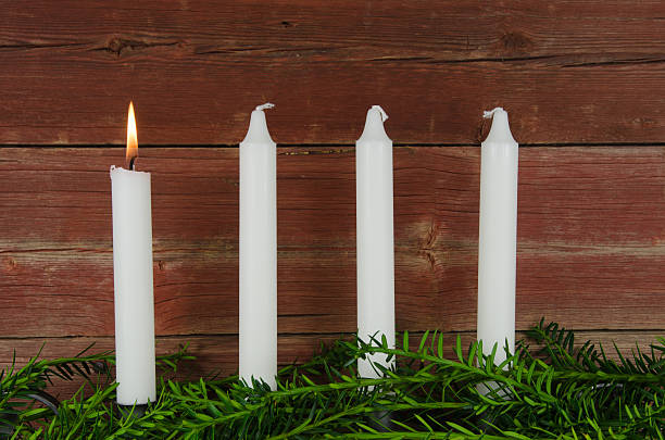 Four advent candles at an old plank wall stock photo
