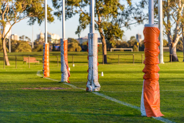 Four Australian football goal posts wrapped with protective padding in a football oval at Carlton, Melbourne, Australia stock photo