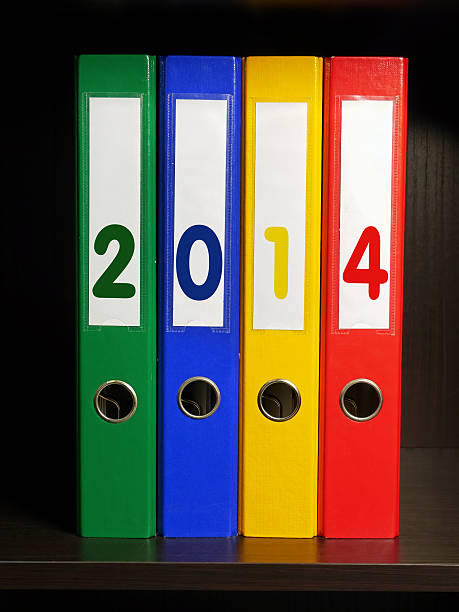 Four color binders with New Year 2014 digits placed on bookshelf