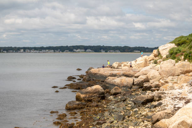 Four children play on the rocks at Bluff Point State park in Groton, Connecticut stock photo