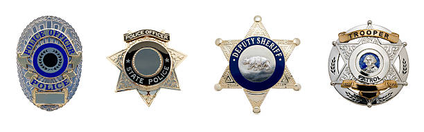 Four different types of law enforcement badges A row of four peace officer badges isolated on white for ease of selection; Metro Police, State Police, Deputy Sheriff and State Trooper. police badge stock pictures, royalty-free photos & images