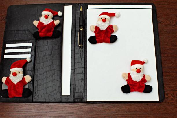 fyra roliga leksaker santa claus på företag läder mapp - santa holding magazine bildbanksfoton och bilder