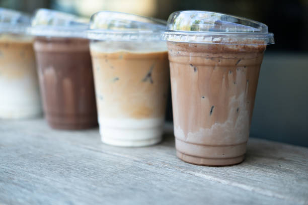 Four glasses of iced coffee drinks on table at outdoor coffee shop Four glasses of iced coffee drinks on table at outdoor coffee shop four cups of coffee on a table stock pictures, royalty-free photos & images