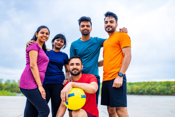 four indian people warming up outdoors in sport wear morning time urban stock photo