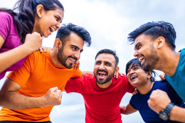 four indian people warming up outdoors in sport wear morning time urban stock photo
