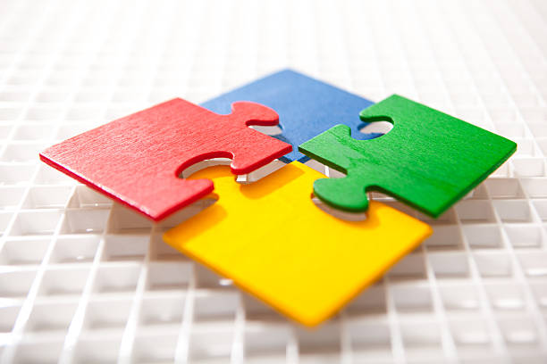 Four multicolored puzzle pieces coming together stock photo