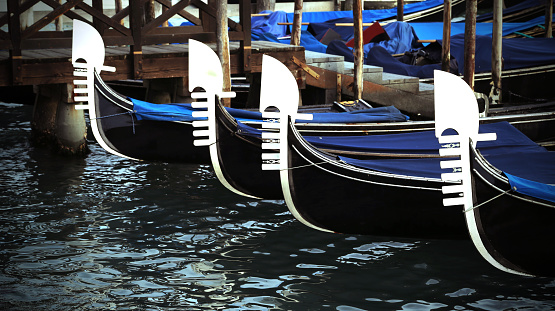 four prows of Venetian gondolas with the characteristic shape of the steel in the lagoon