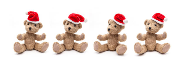 Four teddy bears with Christmas caps sitting on a white background stock photo