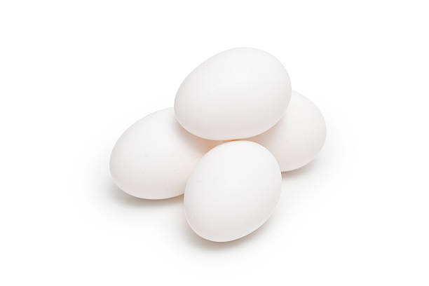 Four White Chicken Eggs Stacked in a Pyramid stock photo