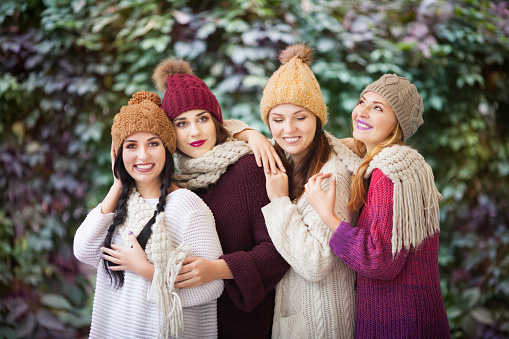 Four Women Best Friends Cuddling In The Park In A Knitted Scarf And ...