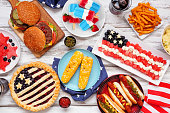 istock Fourth of July, American food. Above view table scene on white wood. 1317295804