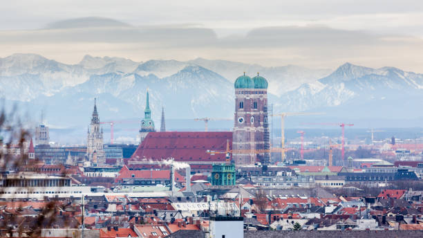 Frauenkirche Munich with snow-capped alps (mountains) in the background. Frauenkirche with snow-capped alps in the background. Symbol & landmark of the bavarian capital. Beautiful panorama captured during winter season. munich stock pictures, royalty-free photos & images
