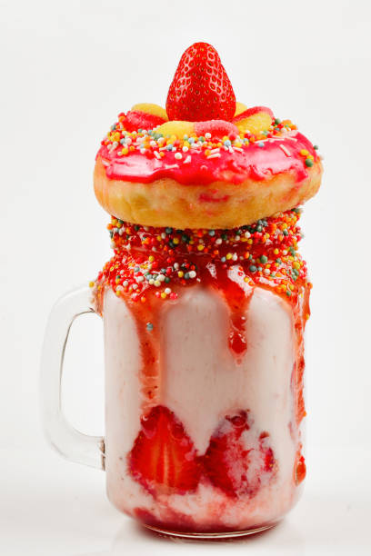 freakshake. extreme milkshake met aardbei, jelly snoepjes, donut. - freakshake fruit stockfoto's en -beelden
