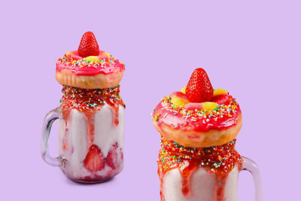 freakshake. extreme milkshake with strawberry, jelly sweets, donut. - freakshake fruit stockfoto's en -beelden