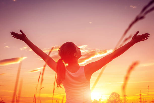 Free and happy woman raises arms against the sunset sky. Harmony and balance Free and happy woman raises arms against the sunset sky. Harmony and balance concept life stock pictures, royalty-free photos & images