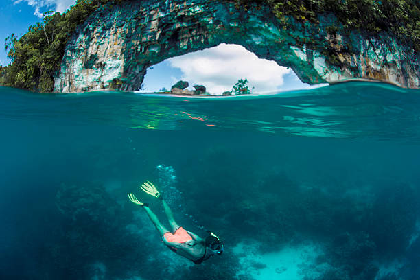 Free diving Female diver in Palau, with  the iconic Rock island Arch in the background babeldaob island stock pictures, royalty-free photos & images