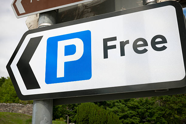 Free Parking Sign A sign pointing towards a free parking area. free sign up stock pictures, royalty-free photos & images