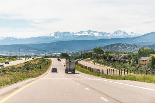 Freeway highway through Colorado towns with cars in traffic and view of snow on rocky mountains Gypsum, USA - June 29, 2019: Freeway highway through Colorado towns with cars in traffic and view of snow on rocky mountains garfield county utah stock pictures, royalty-free photos & images