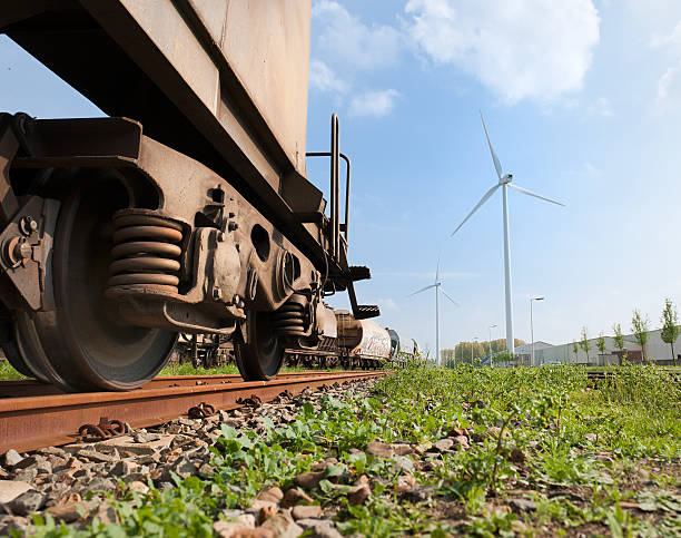freight train "low angle view on a freight train in Rotterdam Harbor, wind turbines in the background, The Netherlands" vertical axis wind turbine stock pictures, royalty-free photos & images