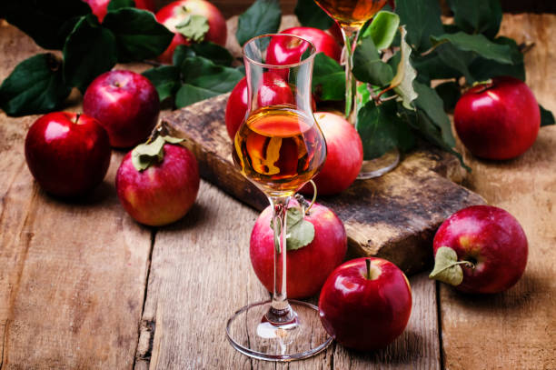 French apple strong alcoholic drink, still life in rustic style French apple strong alcoholic drink, still life in rustic style, vintage wooden background, selective focus calvados stock pictures, royalty-free photos & images