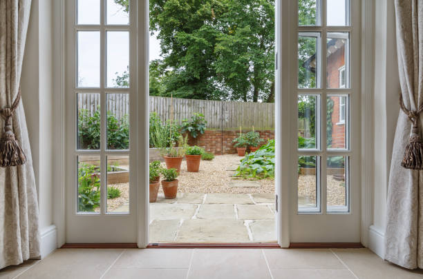 French doors leading to kitchen garden View of garden from inside house with french doors leading to a courtyard kitchen garden looking through window stock pictures, royalty-free photos & images