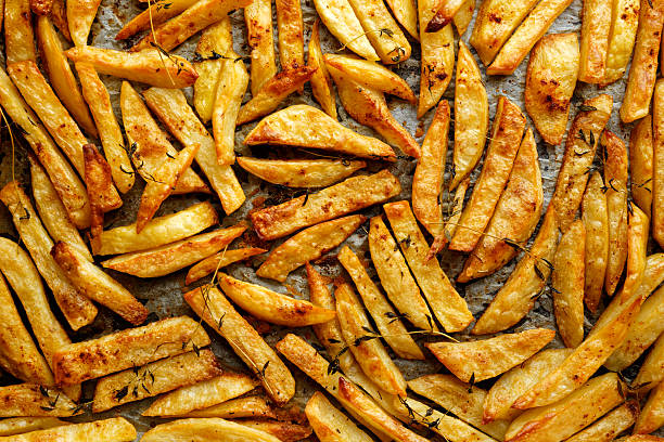 french fries with addition herbs - gebakken in de oven stockfoto's en -beelden