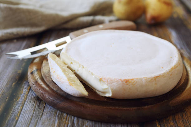French Reblochon cheese on cutting board stock photo
