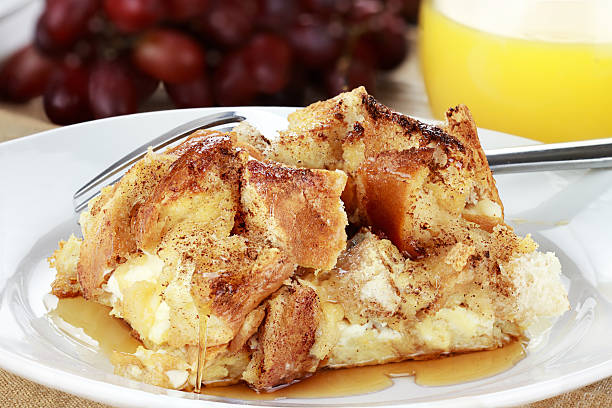 French Toast Casserole French toast casserole with maple syrup. Made with cream cheese cheese in the center. Fresh grapes and orange juice in background. casserole stock pictures, royalty-free photos & images